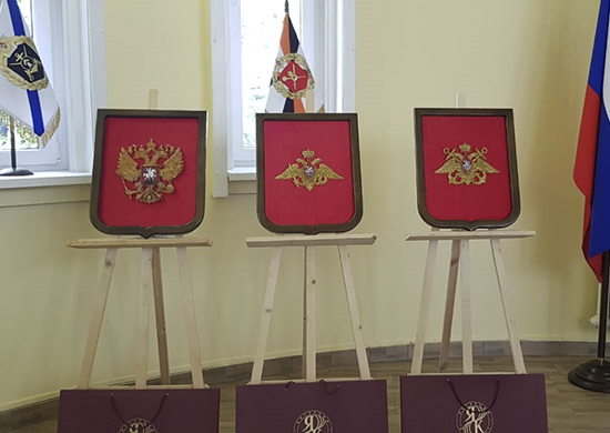 Музею 11 общевойсковой армии передали три янтарных панно с изображением гербов